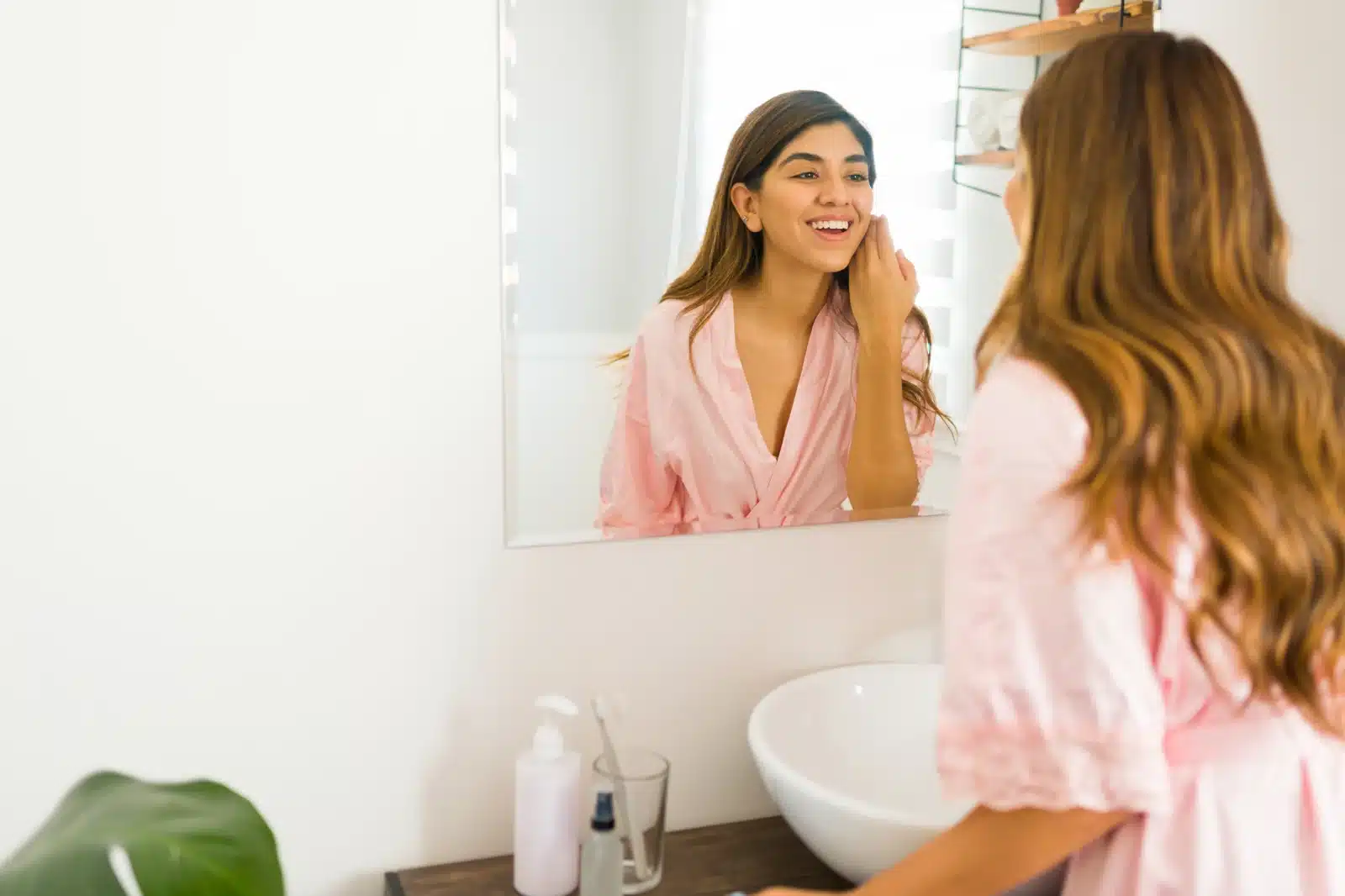 A woman looking at her refreshed features in a mirror at a Thonotosassa, FL medical spa after dermal filler.
