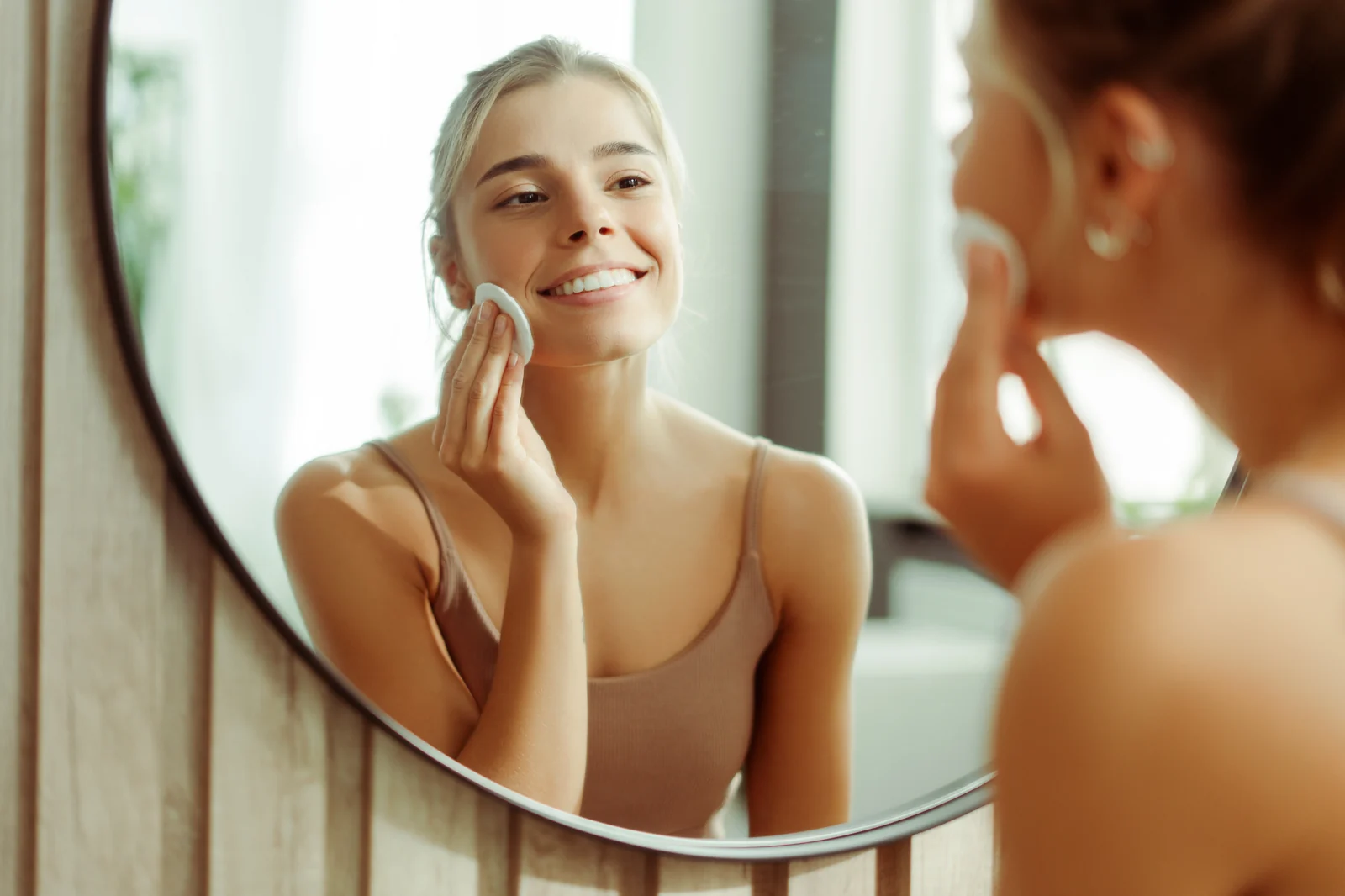 A woman reviewing her lips in a mirror after a hyaluronidase filler-dissolving treatment at a Thonotosassa, FL medical spa.