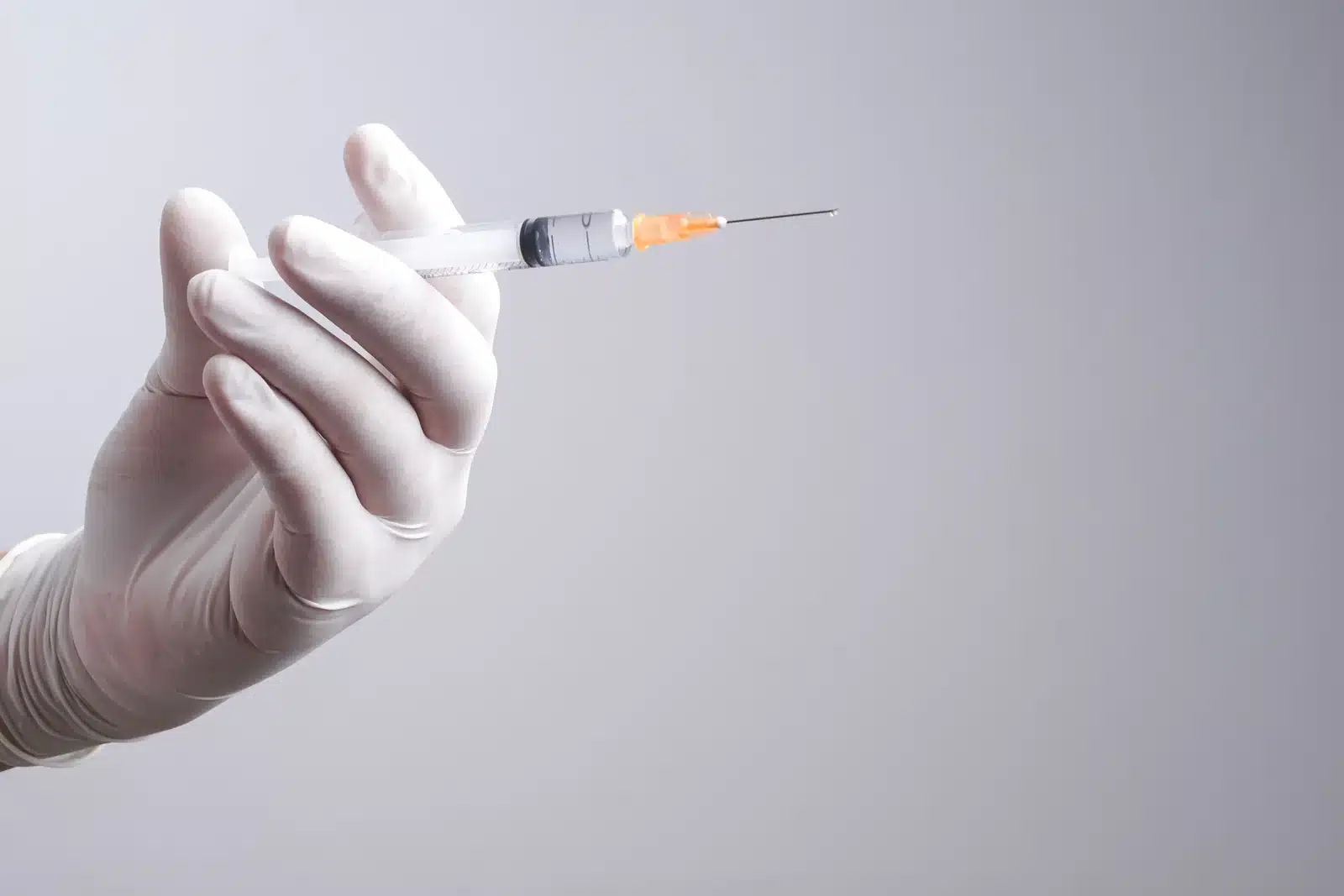 A clinician holding a prepared syringe in a sterile glove, representing the physician-led lip flip safety protocol at SpaRx Medical Aesthetics in Thonotosassa, FL.